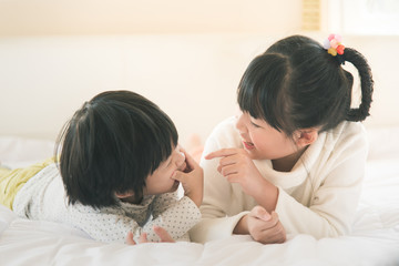 Wall Mural - asian children lying on white bed