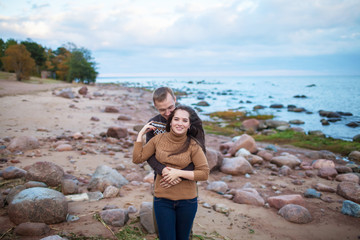 Wall Mural - Young couple hugging on a rocky seashore