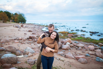 Wall Mural - Young couple hugging on a rocky seashore