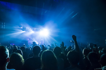 silhouettes of concert crowd in front of bright stage lights