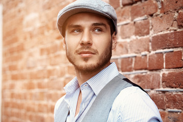 Wall Mural - casual young man stands with his back against a brick wall