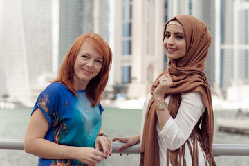 Wall Mural - Smiling girl in hijab covering her eyes with happiness in Dubai Marina