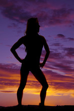 Silhouette Of Woman Standing Hands On Hips In Sunset