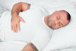 © Solid photos - Muscular bodybuilder with tribal tattoos sleeping in bed