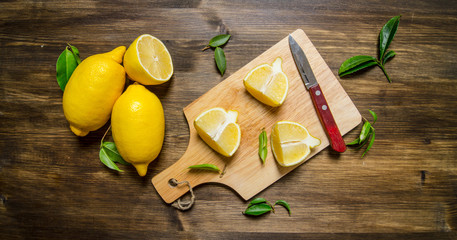 Sliced lemon on the board with leaves.