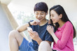 © Blue Jean Images - Young couple listening to earphones