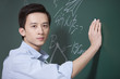© Blue Jean Images - Professional male teacher writing on blackboard