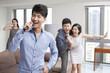© Blue Jean Images - Happy young friends singing and dancing in living room