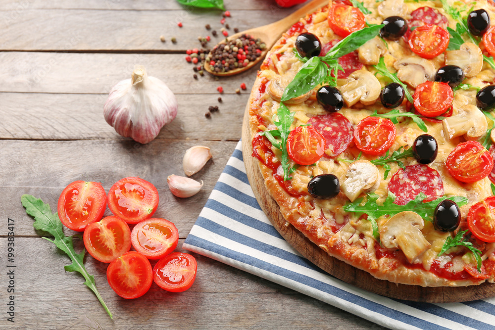 Delicious tasty pizza with ingredients on wooden table