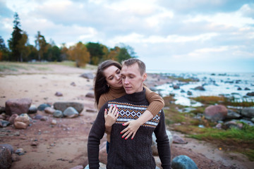 young couple sitting on a rock on the beach