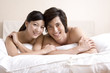 © Blue Jean Images - Asian couple close to each other on bed
