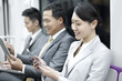 © Blue Jean Images - Business persons using digital products in subway train