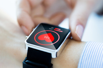 Poster - close up of hands with heart icon on smartwatch