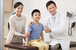 © Blue Jean Images - Doctor with boy and young woman in examination room