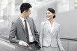 © Blue Jean Images - Young business partners talking on escalator