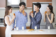 © Blue Jean Images - Happy young friends eating breakfast in the kitchen