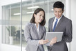 © Blue Jean Images - Business person looking at digital tablet together