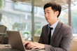 © twinsterphoto - Young Asian businessman working with his laptop in outdoor scene