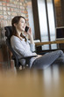 © Blue Jean Images - Young woman talking on the phone in office