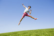 © Blue Jean Images - Cheerful young man jumping on grass