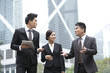 © Blue Jean Images - Happy business persons talking while on the move, Hong Kong