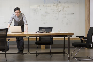 Young man using digital tablet in board room