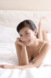 © Blue Jean Images - Asian woman on bed