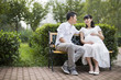 © Blue Jean Images - Pregnant woman and her husband sitting on bench