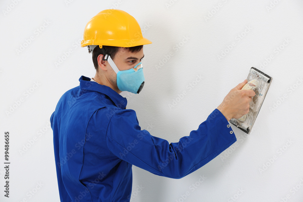 Worker renewing apartment on wall background