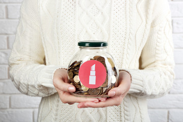 Wall Mural - Woman hands with money in glass jar, close up