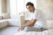 © Blue Jean Images - Portrait of young man sitting on bed