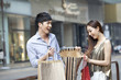 © Blue Jean Images - Happy young woman opening a gift bag from young man with surprise and excitement, Hong Kong