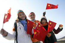 Young People Waving Flags On The Great Wall Of China