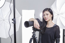 Photographer Standing In Studio With Camera