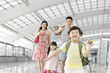© Blue Jean Images - Happy family with luggage at the airport