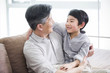 © Blue Jean Images - Cute grandson sitting on grandfather's lap