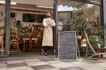 Barista standing in door of a coffee shop