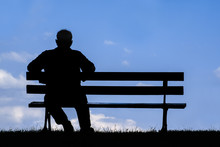 Old Man Sitting Alone On Park Bench Under Tree