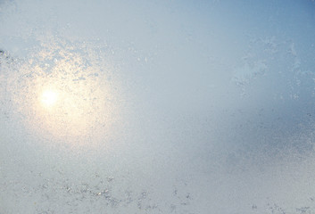 Frozen white window covered with frost in winter patterned.