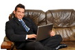 © petrdlouhy - Handsome businessman in suit sitting on sofa and works on the computer