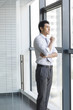 © Blue Jean Images - Young businessman looking through window