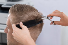 Man Getting Haircut From Hairdresser At Salon