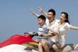 © Blue Jean Images - Happy family riding on a jet ski