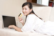 © Blue Jean Images - Asian woman with credit card and laptop