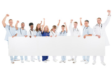 Wall Mural - Happy Medical Team With Arms Raised Holding Blank Billboard
