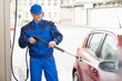© Andrey Popov - Serviceman With High Pressure Water Jet Washing Car