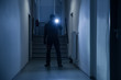 © Andrey Popov - Burglar With Flashlight And Crowbar In Office Corridor