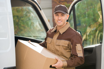 Wall Mural - Young Delivery Man Removing Cardboard Box From Truck