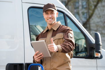 Wall Mural - Smiling Delivery Man Holding Digital Tablet Against Truck