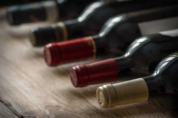 Row of wine bottles on the wooden table. Low depth of field.